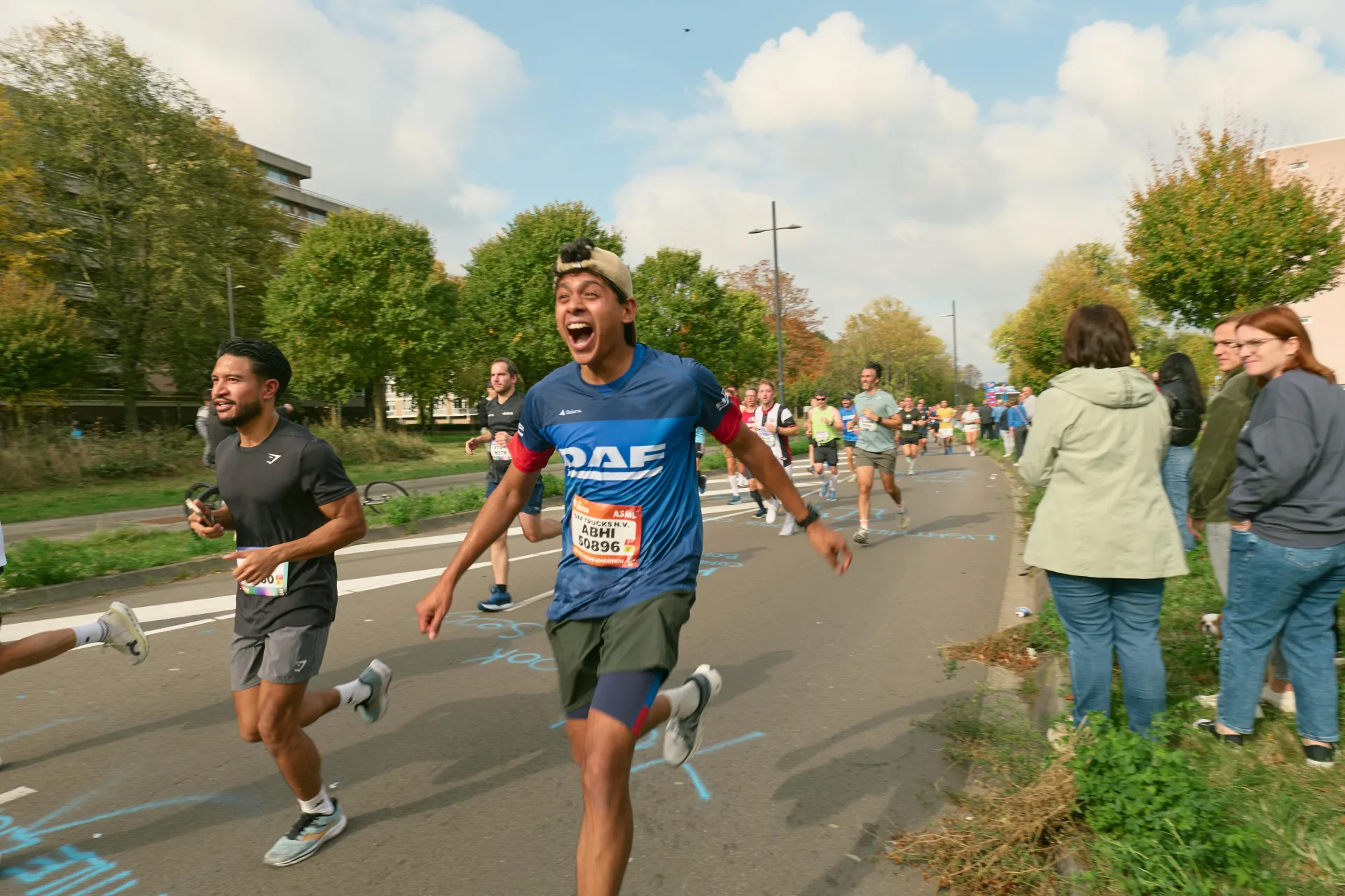 A Lightmile runner cheering with arms wide, mid-race