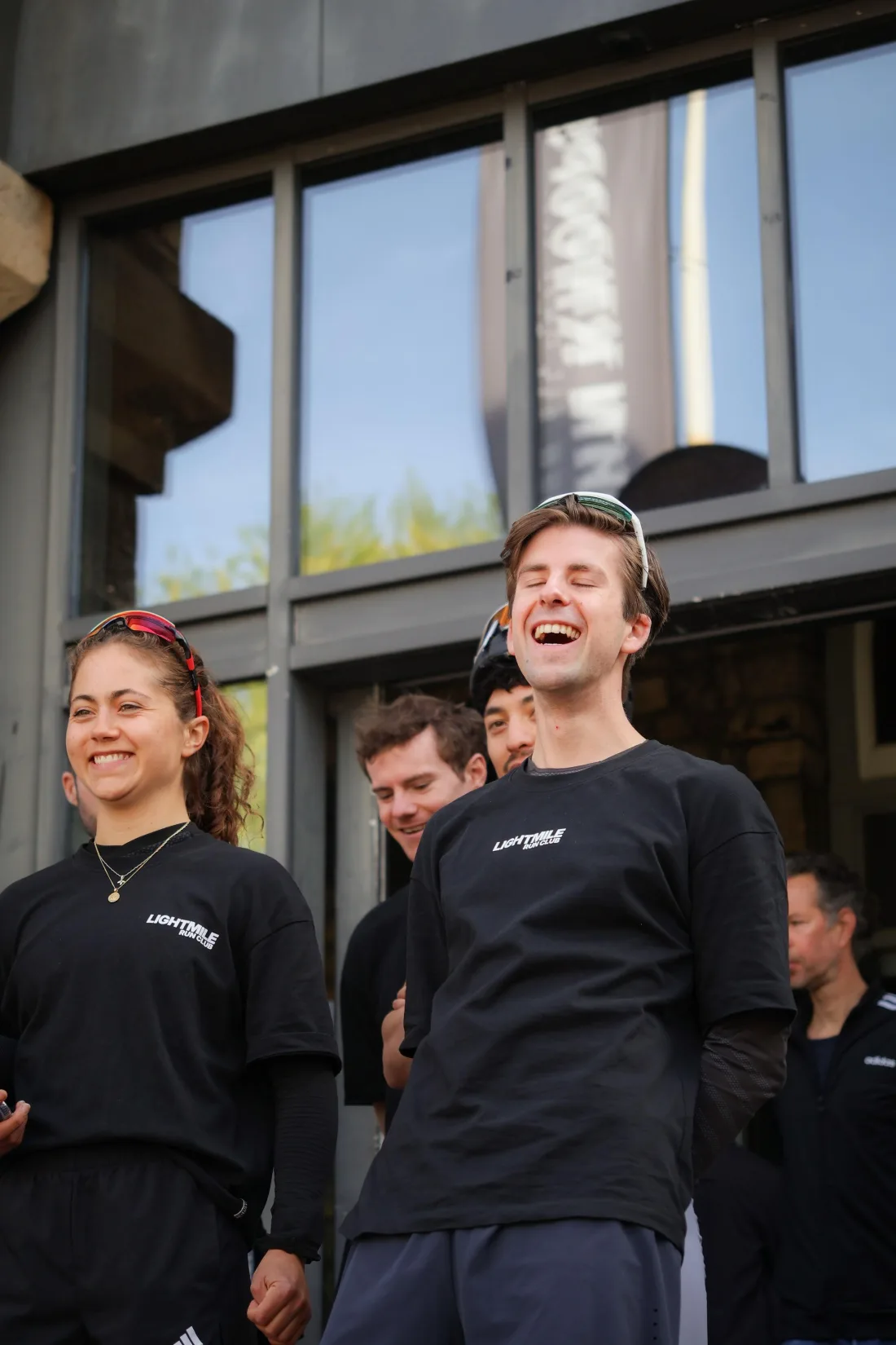 Two runners in Lightmile shirts laughing together outdoors